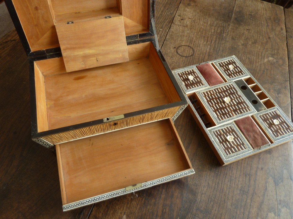 An Anglo-Indian sarcophagus-form workbox featuring porcupine quill panels, engraved bone borders, and a sunburst horn and bone lid finial. View VI