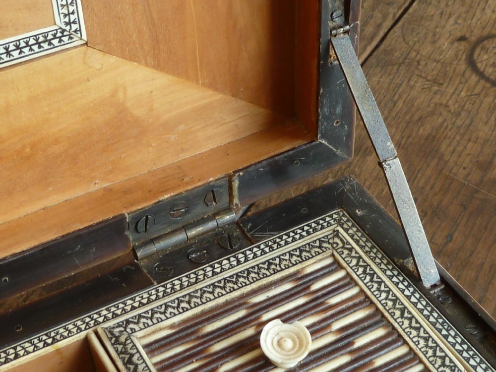 An Anglo-Indian sarcophagus-form workbox featuring porcupine quill panels, engraved bone borders, and a sunburst horn and bone lid finial. View IX