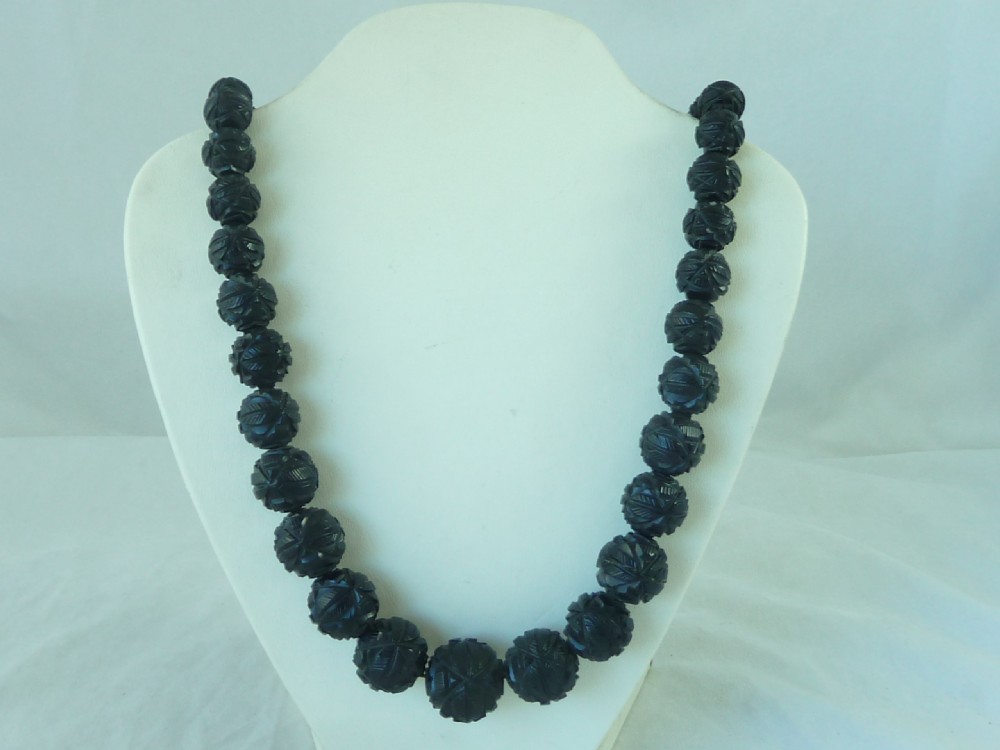 A strand of graduated Victorian Whitby jet beads with hand-carved geometric patterns. View II