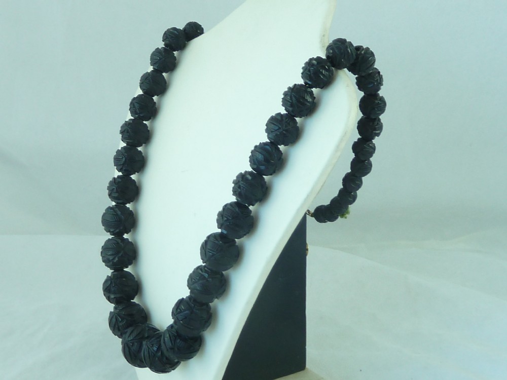 A strand of graduated Victorian Whitby jet beads with hand-carved geometric patterns. View III