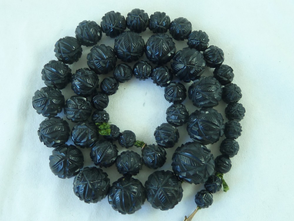 A strand of graduated Victorian Whitby jet beads with hand-carved geometric patterns. View IV
