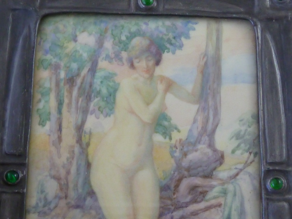 A rectangular Art Deco miniature painting of a nude female figure amongst trees, enclosed in a dark metal frame inset with green glass cabochons. View V