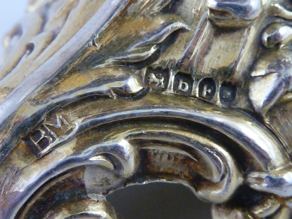 A Hanau silver gilt sugar caster featuring elaborate Rococo relief scenes of figures in a landscape and a pierced finial lid. View VI