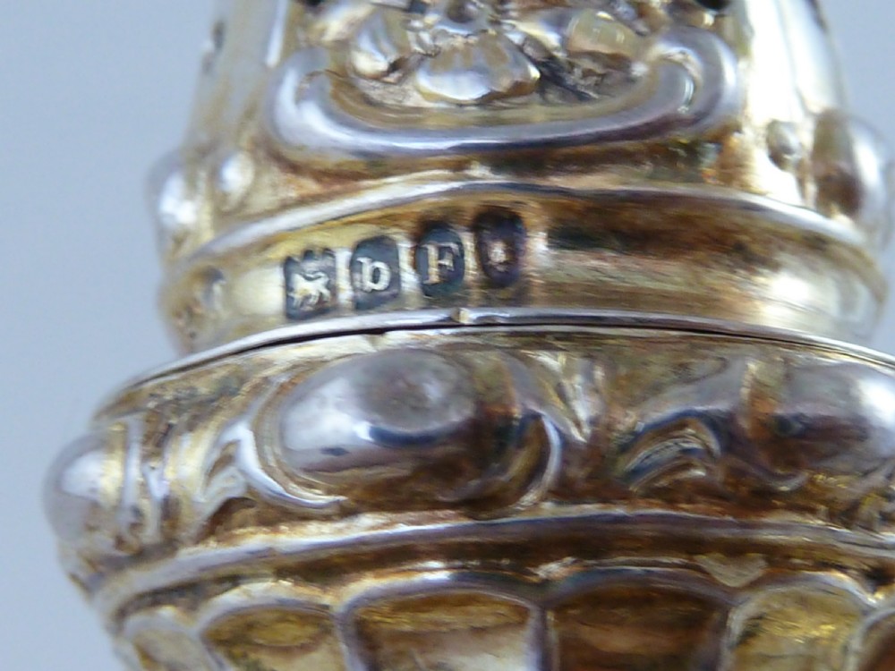 A Hanau silver gilt sugar caster featuring elaborate Rococo relief scenes of figures in a landscape and a pierced finial lid. View VII