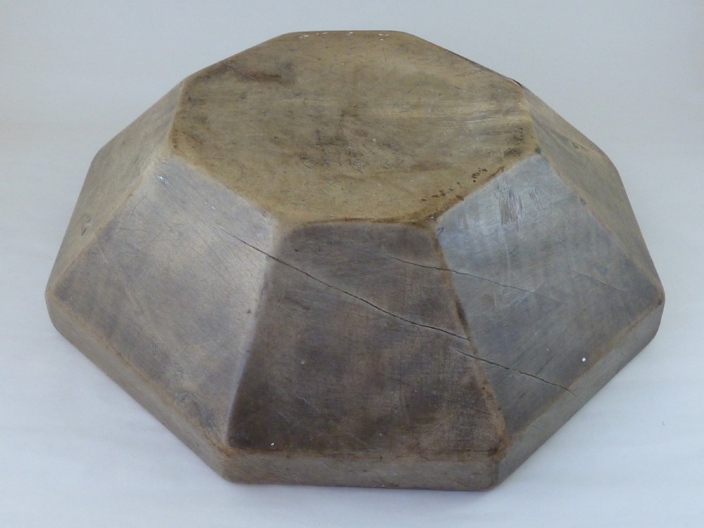 An octagonal carved sycamore wooden bowl featuring a recessed circular interior well and aged timber patina. View VI