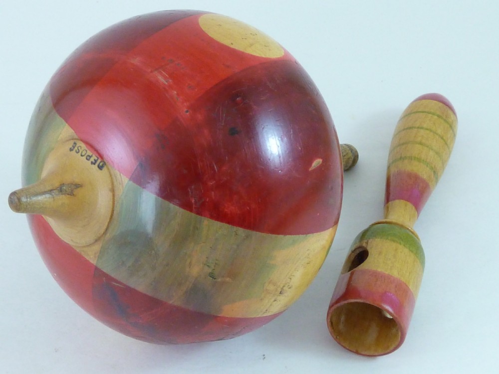 A turned wooden humming spinning top featuring polychrome painted bands in red, green, and yellow with an attached turned wooden handle. View III