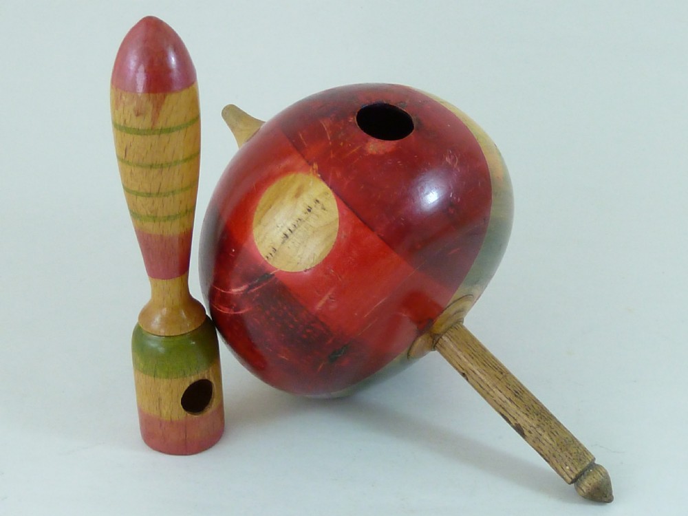 A turned wooden humming spinning top featuring polychrome painted bands in red, green, and yellow with an attached turned wooden handle. View IV