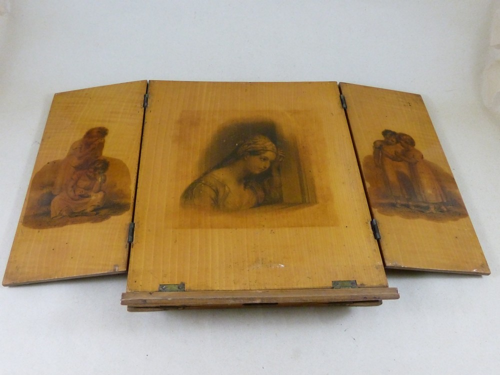 A Victorian Mauchline ware folding wooden reading stand in pale wood featuring black transfer prints of classical figures across three panels. View V