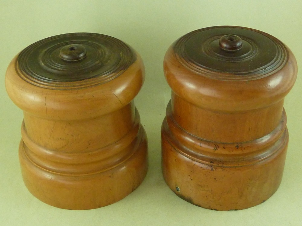 A near pair of turned lignum vitae wooden string holders with cylindrical barrels and rounded tops. View II