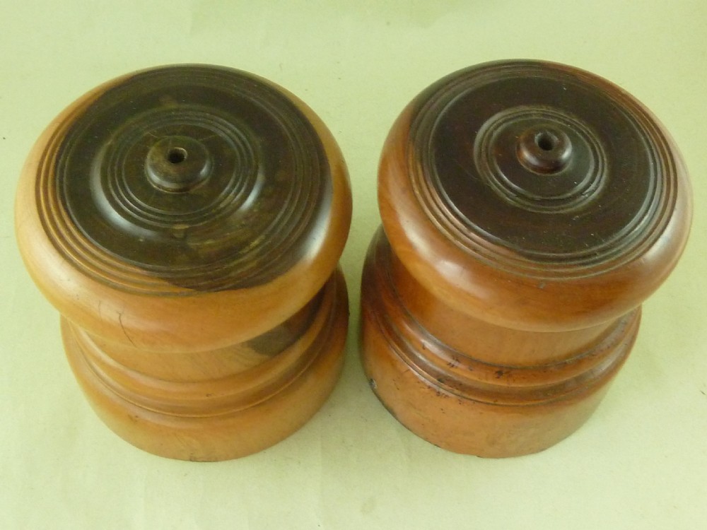 A near pair of turned lignum vitae wooden string holders with cylindrical barrels and rounded tops. View III