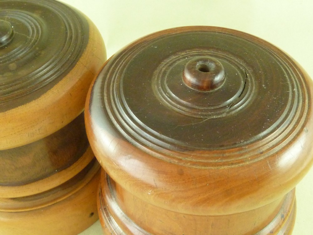 A near pair of turned lignum vitae wooden string holders with cylindrical barrels and rounded tops. View VI