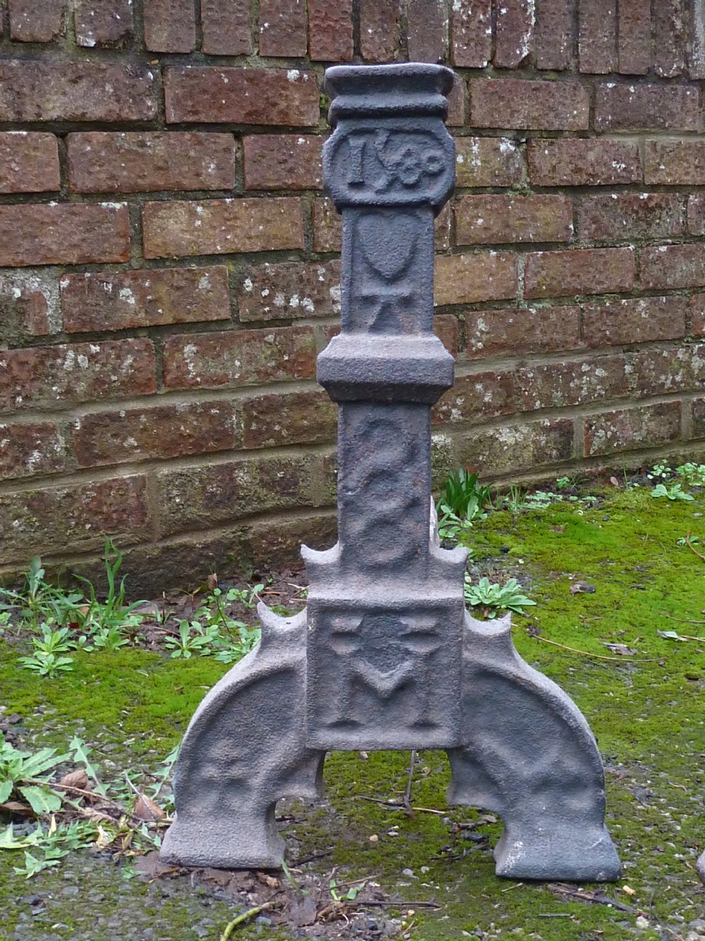 A pair of heavy cast iron Elizabethan fire dogs featuring upright columnar shafts, raised date markings, and broad arched legs. View VIII