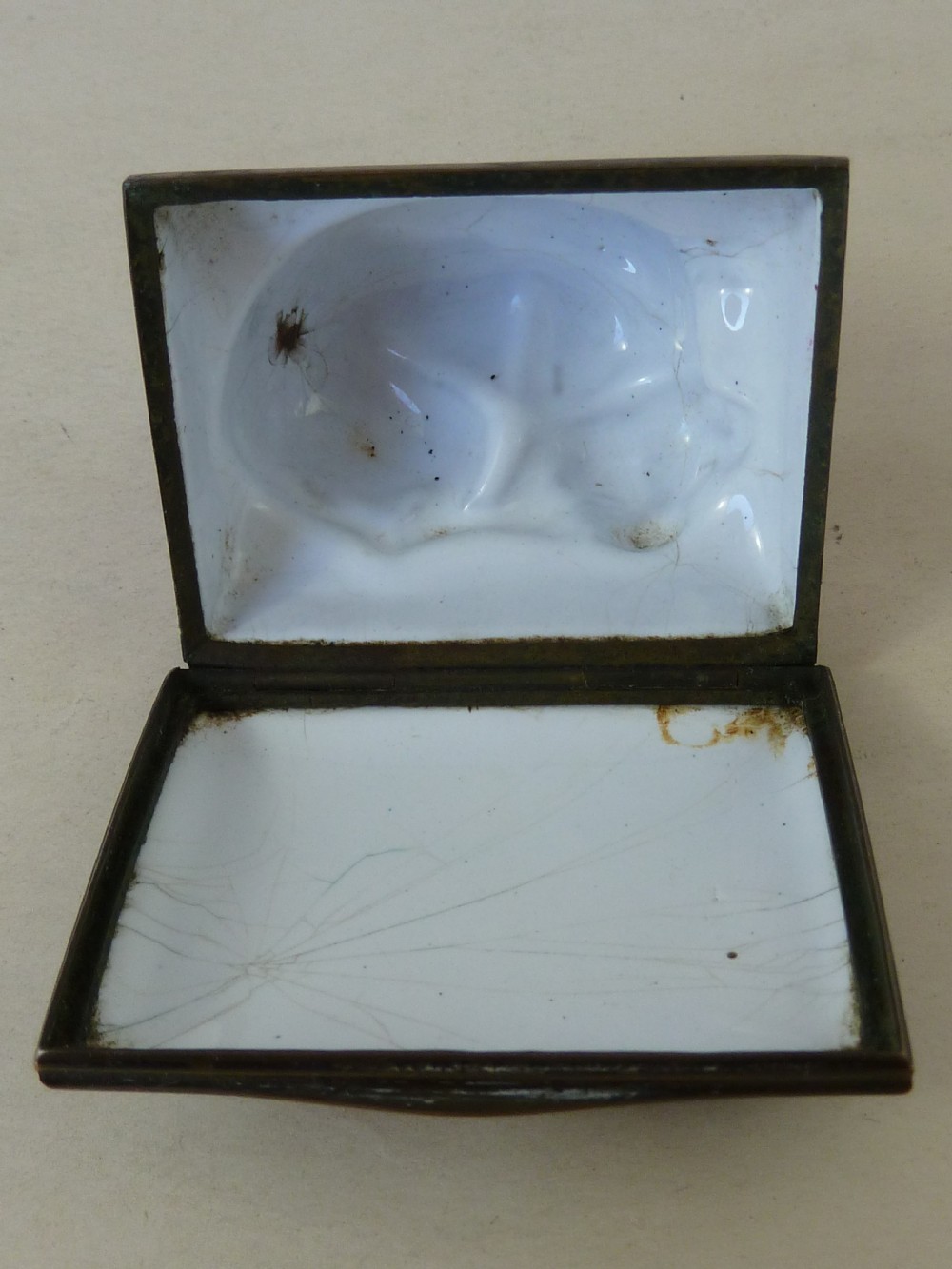 An eighteenth-century Bilston enamel snuff box depicting a black and white King Charles spaniel curled on a magenta cushion base with metal mounts. View III
