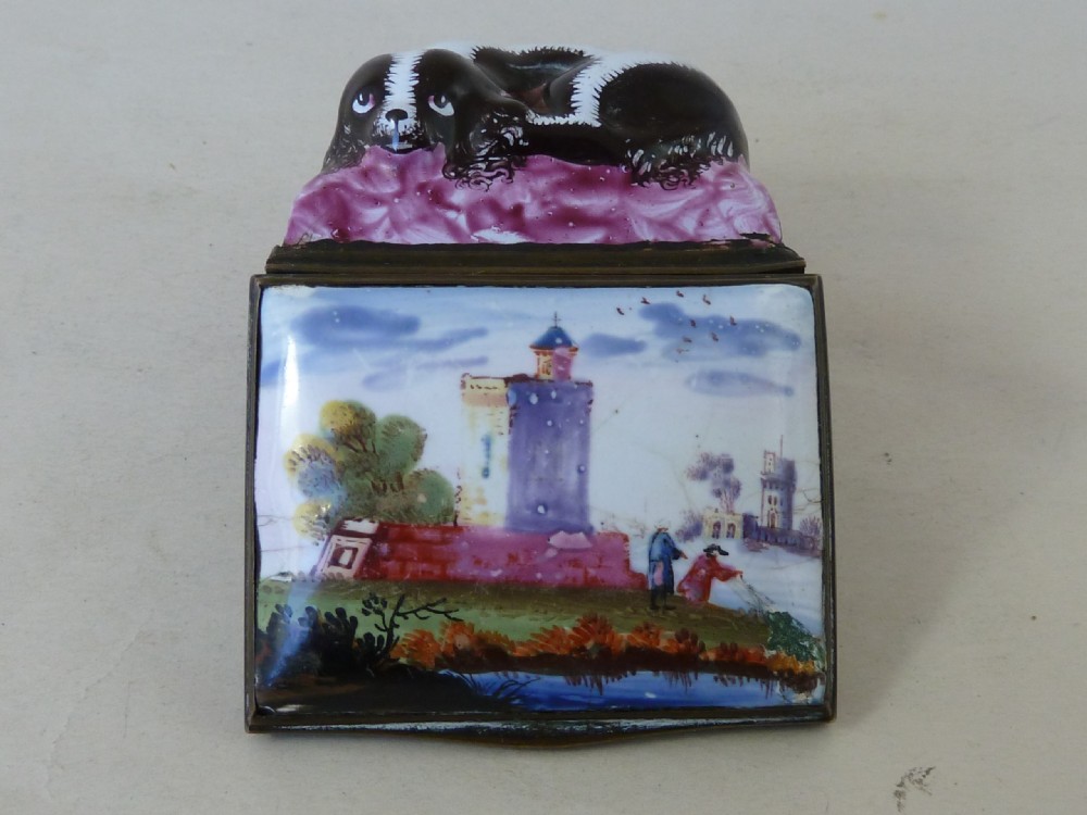 An eighteenth-century Bilston enamel snuff box depicting a black and white King Charles spaniel curled on a magenta cushion base with metal mounts. View IV