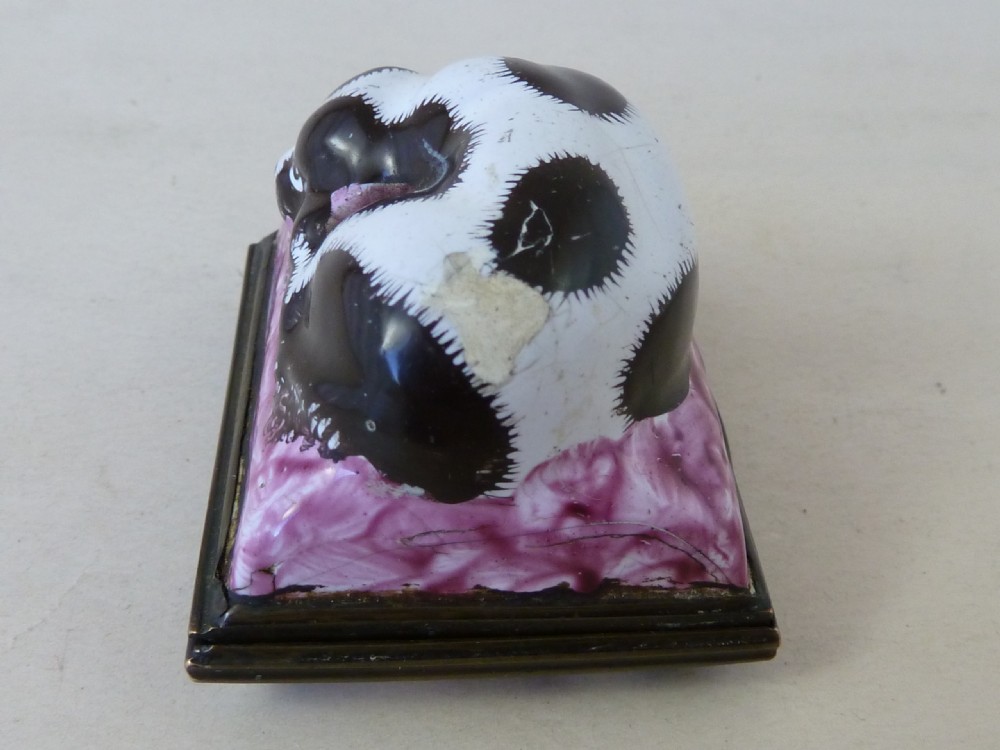 An eighteenth-century Bilston enamel snuff box depicting a black and white King Charles spaniel curled on a magenta cushion base with metal mounts. View VI