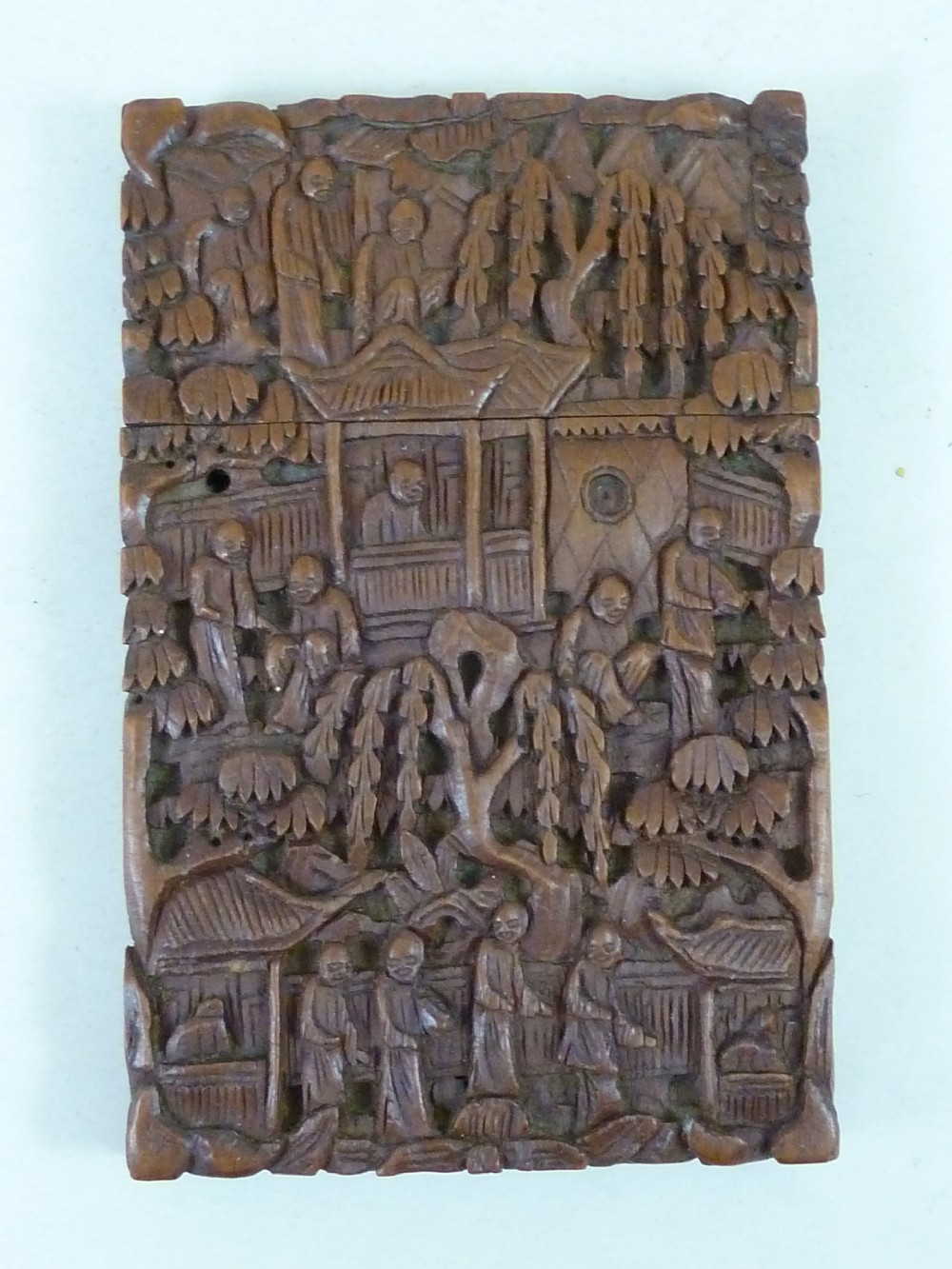 A rectangular nineteenth-century Chinese sandalwood visiting card case featuring high-relief relief carvings of figures, pavilions, and trees.