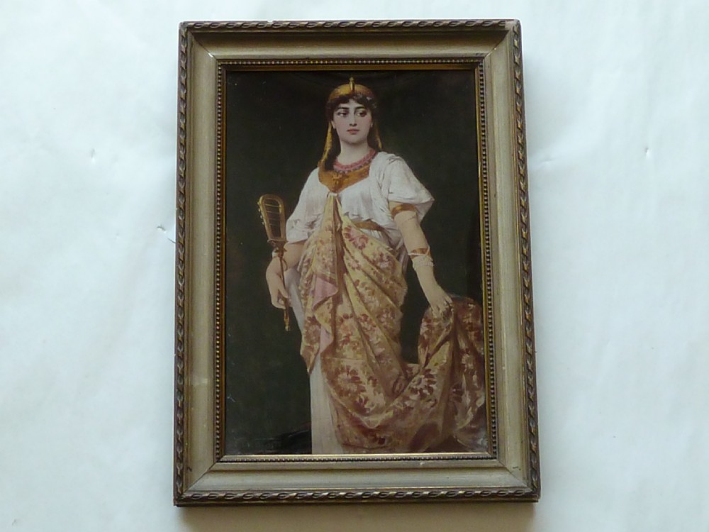 A framed Victorian chrystoleum reverse glass print depicting a figure in Egyptian Revival attire holding a musical instrument inside a gilded wooden frame. View II