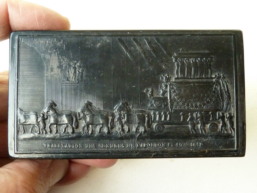 A rectangular dark pressed horn snuff box featuring a relief moulding of Napoleons funeral procession on the lid.