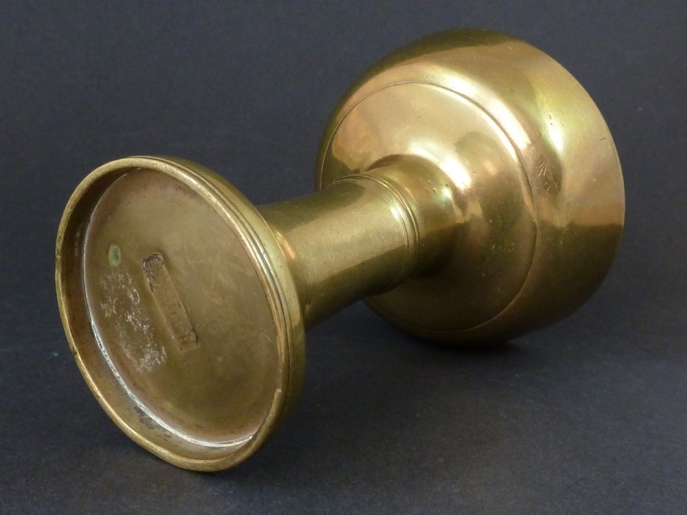 A solid brass Tibetan butter lamp displaying a flared circular base, knopped stem, and wide shallow rimmed upper bowl. View VI