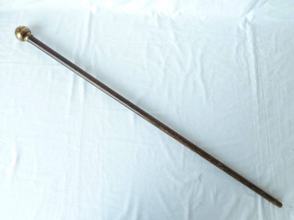 An antique walking stick featuring a round steel ball handle with intricate gold damascene inlay mounted on a dark palm wood shaft. View VII