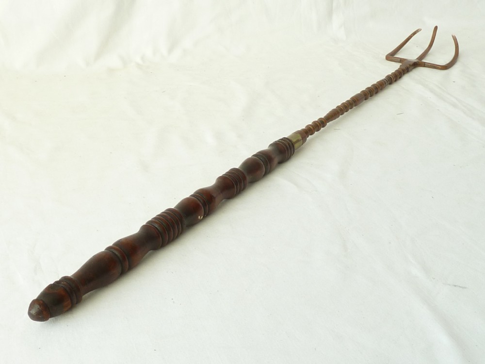 A Georgian copper toasting fork featuring three curved prongs, a knopped metal stem, and a dark turned mahogany wooden handle. View VI