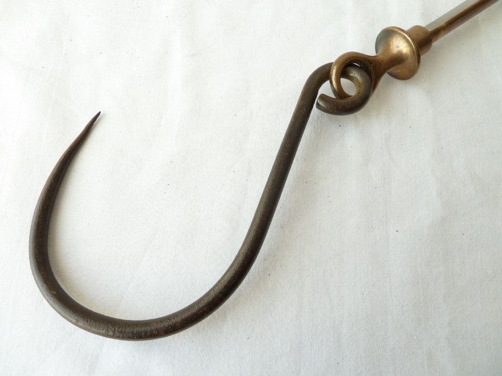 A Georgian wrought iron and brass roasting trammel hook featuring a large hand-forged iron hook attached to a cylindrical brass sleeve with a turned finial. View IV