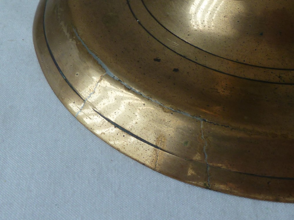 A turned cast brass candlestick featuring a wide circular base, a central knop stem, and a single socket with an extraction hole. View VII