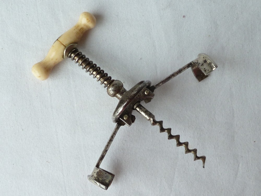 An antique German Columbus mechanical steel corkscrew featuring a carved bone T-handle and a tension spring shaft. View III