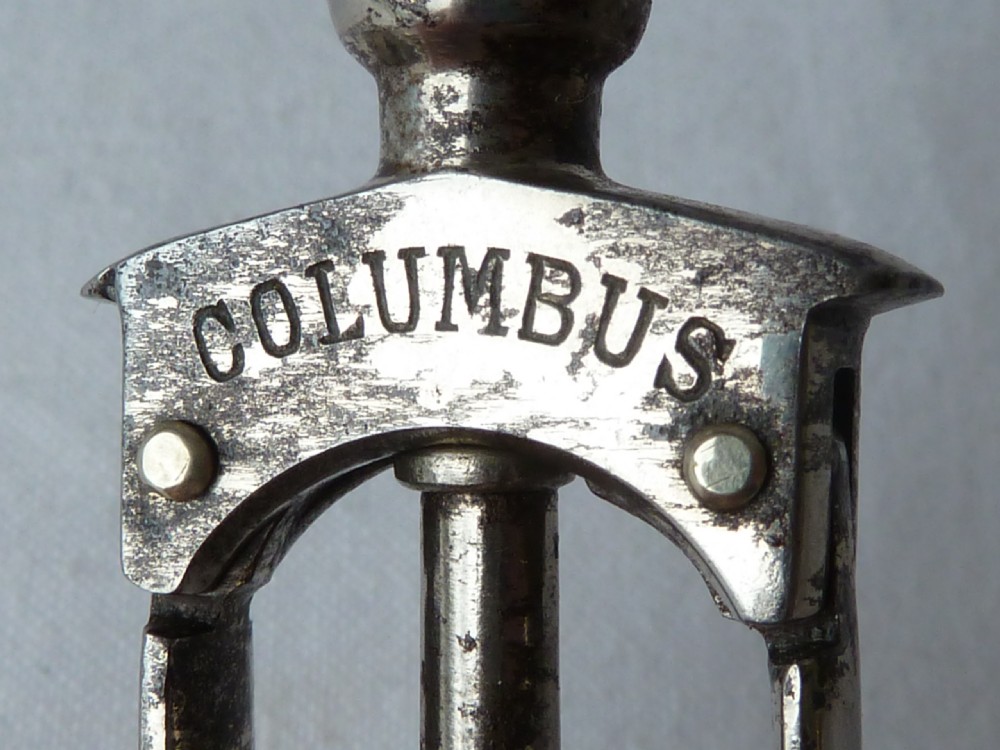 An antique German Columbus mechanical steel corkscrew featuring a carved bone T-handle and a tension spring shaft. View V