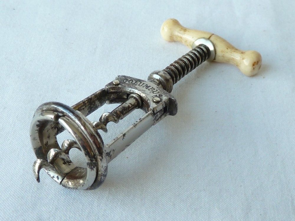 An antique German Columbus mechanical steel corkscrew featuring a carved bone T-handle and a tension spring shaft. View VI