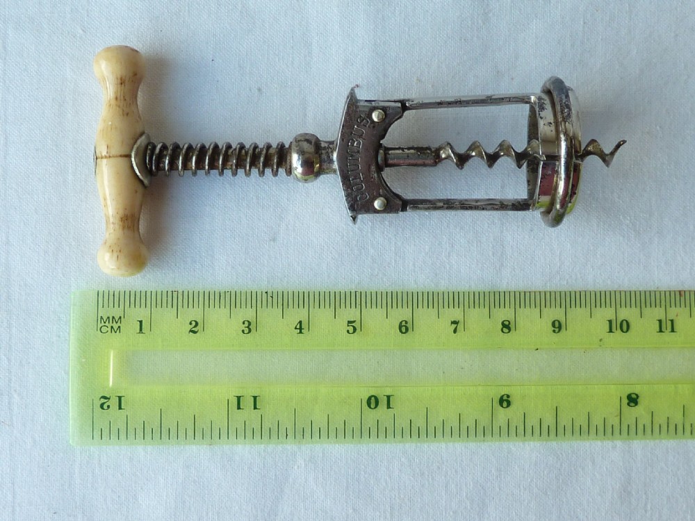An antique German Columbus mechanical steel corkscrew featuring a carved bone T-handle and a tension spring shaft. View VIII