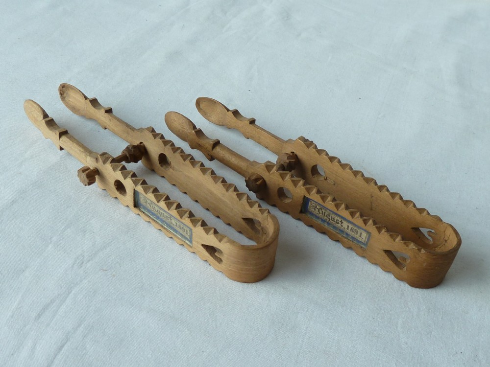 A pair of hand-carved Victorian Welsh wooden sugar tongs with serrated edges, heart cutouts, turned knobs, and inset name plates reading Miss Williams. View II