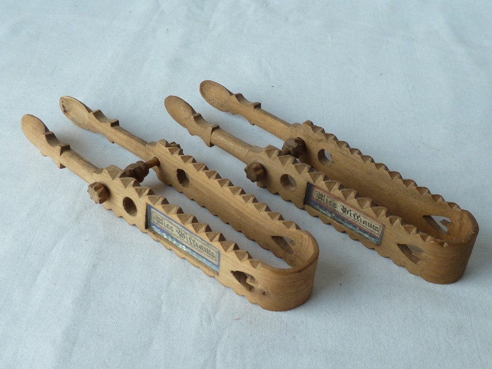 A pair of hand-carved Victorian Welsh wooden sugar tongs with serrated edges, heart cutouts, turned knobs, and inset name plates reading Miss Williams. View III