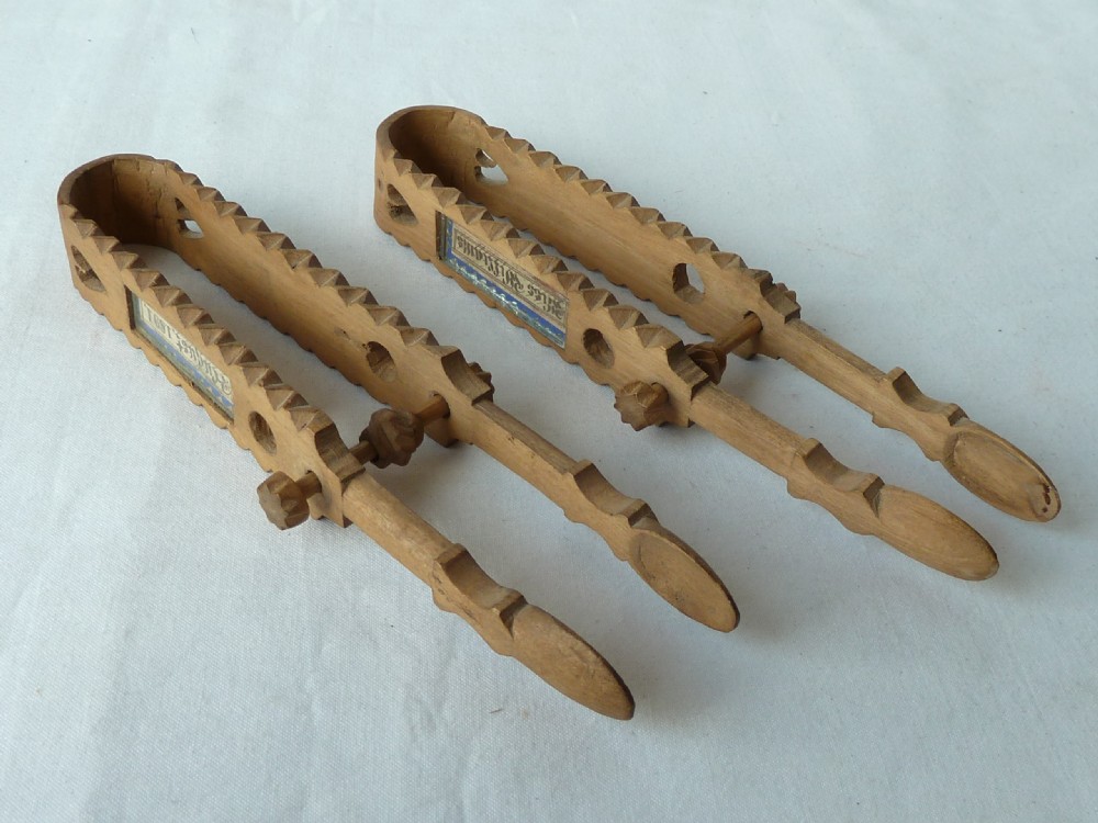 A pair of hand-carved Victorian Welsh wooden sugar tongs with serrated edges, heart cutouts, turned knobs, and inset name plates reading Miss Williams. View V