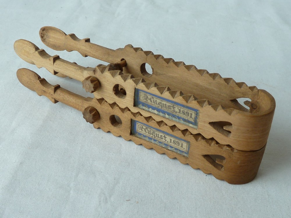 A pair of hand-carved Victorian Welsh wooden sugar tongs with serrated edges, heart cutouts, turned knobs, and inset name plates reading Miss Williams. View VI