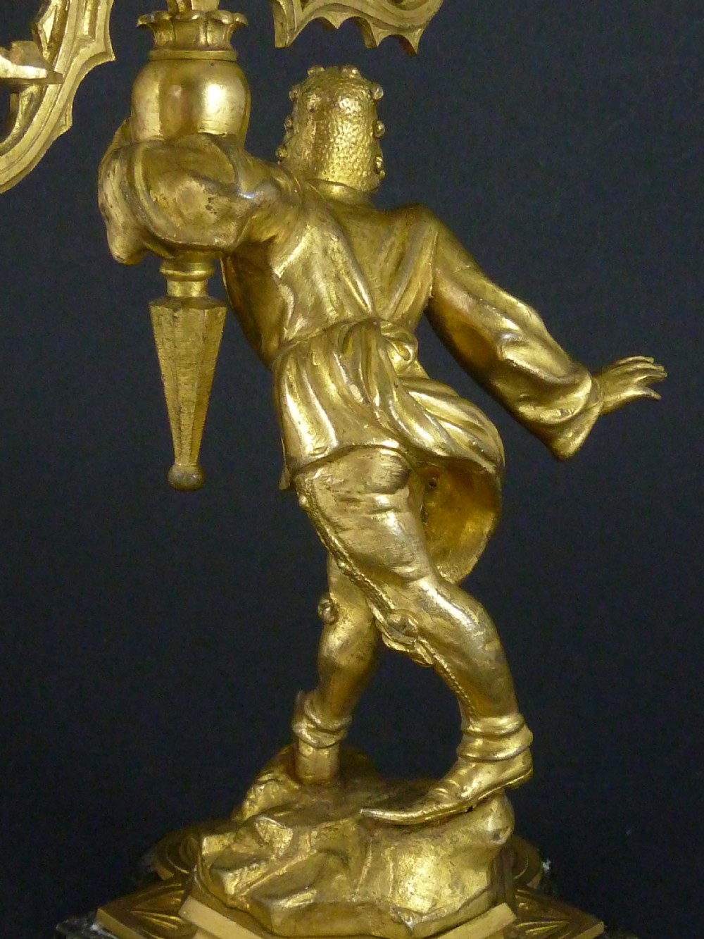 A pair of gilt bronze twin-light figural candelabra featuring sculpted Renaissance figures supporting branching candle arms set upon dark marble bases. View IV