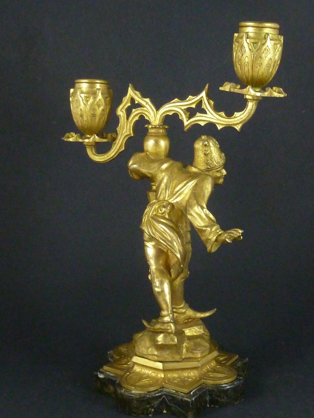 A pair of gilt bronze twin-light figural candelabra featuring sculpted Renaissance figures supporting branching candle arms set upon dark marble bases. View V