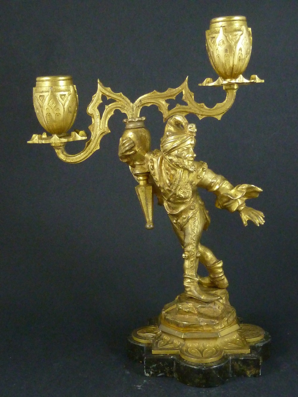 A pair of gilt bronze twin-light figural candelabra featuring sculpted Renaissance figures supporting branching candle arms set upon dark marble bases. View VI