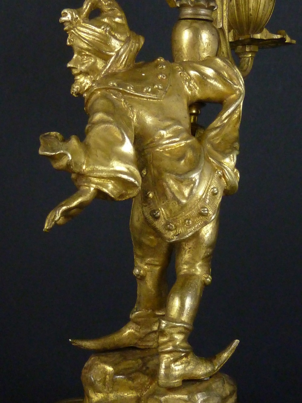 A pair of gilt bronze twin-light figural candelabra featuring sculpted Renaissance figures supporting branching candle arms set upon dark marble bases. View IX