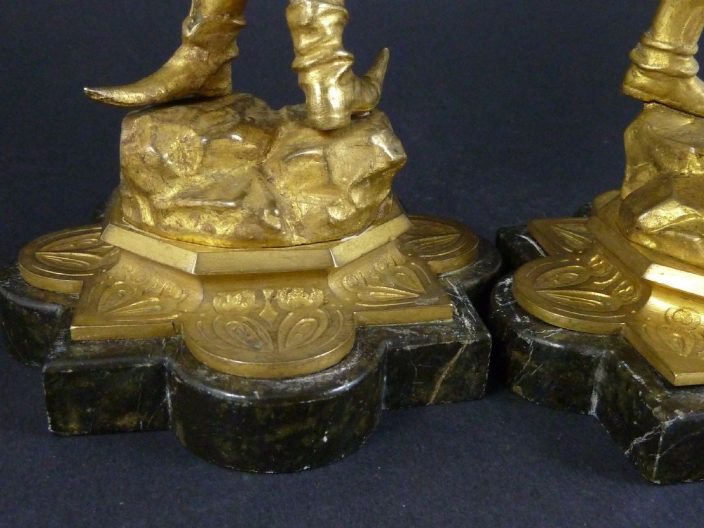 A pair of gilt bronze twin-light figural candelabra featuring sculpted Renaissance figures supporting branching candle arms set upon dark marble bases. View XI