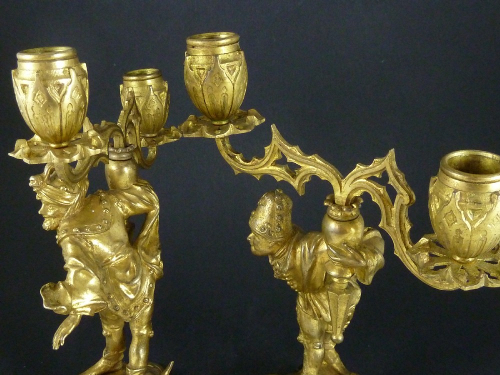 A pair of gilt bronze twin-light figural candelabra featuring sculpted Renaissance figures supporting branching candle arms set upon dark marble bases. View XII