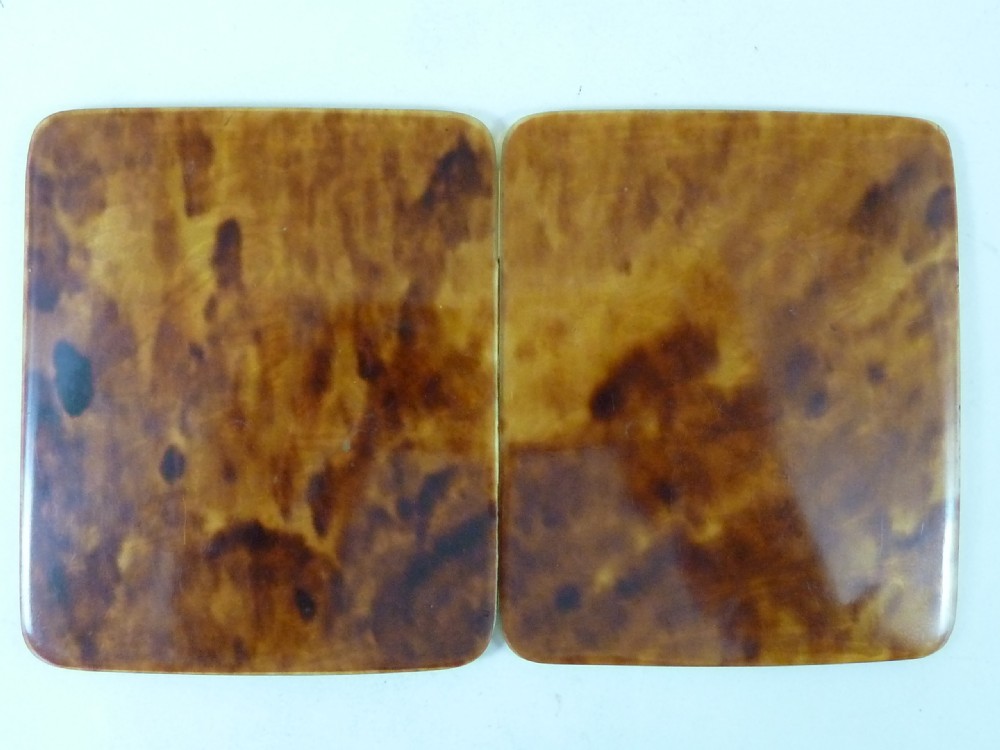 A closed two-panel Art Deco magic wallet with a mottled amber brown tortoiseshell exterior and rounded edges.