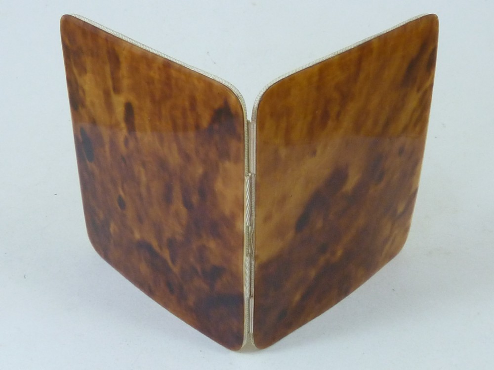 A closed two-panel Art Deco magic wallet with a mottled amber brown tortoiseshell exterior and rounded edges. View II