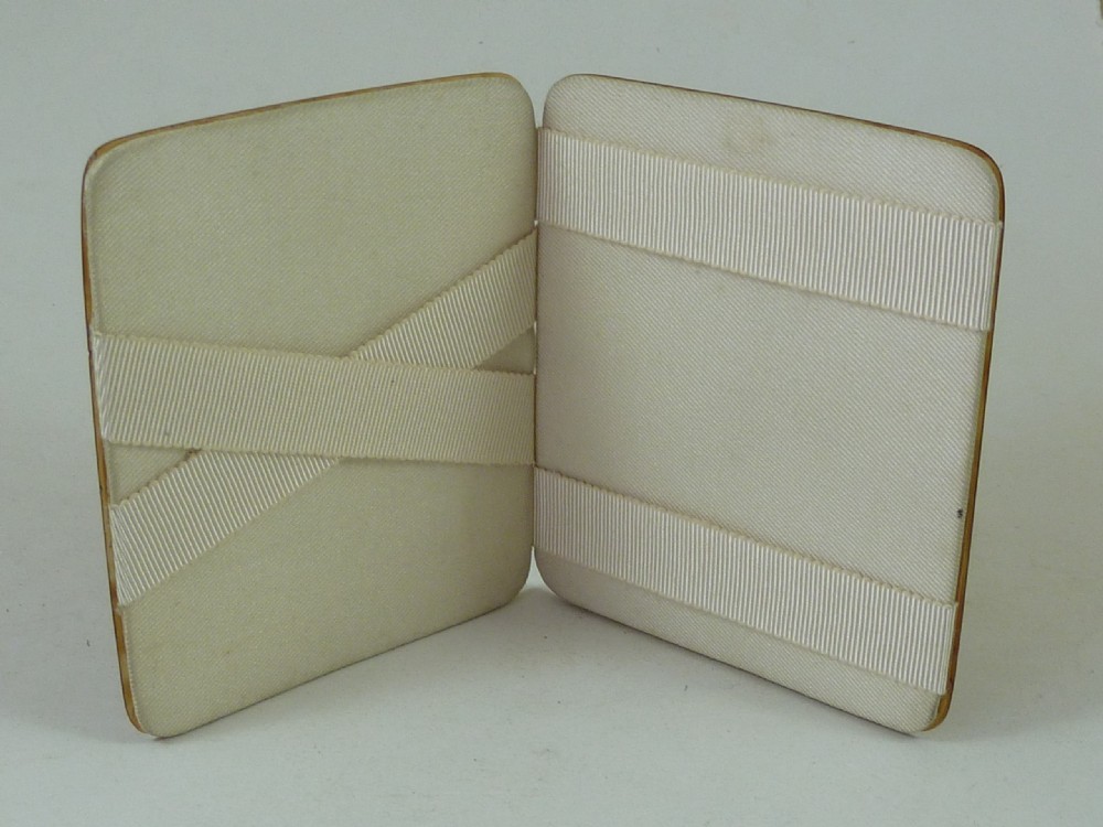 A closed two-panel Art Deco magic wallet with a mottled amber brown tortoiseshell exterior and rounded edges. View III