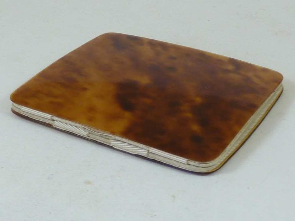 A closed two-panel Art Deco magic wallet with a mottled amber brown tortoiseshell exterior and rounded edges. View VI