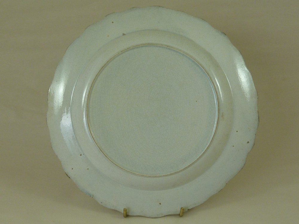An antique pearlware plate featuring a hand-painted peafowl on a branch framed by a blue feather-edge rim. View III