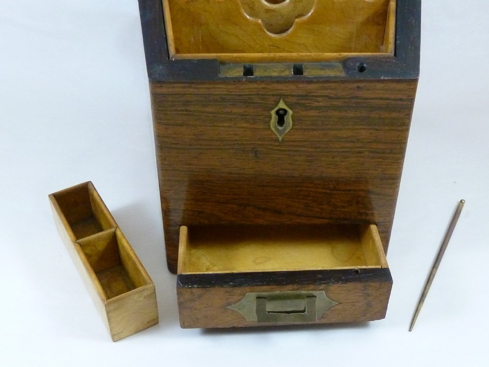 A Victorian rosewood sloping desktop stationery cabinet with open hinged lid revealing tiered light-wood compartments and a lower drawer with brass handle. View VI