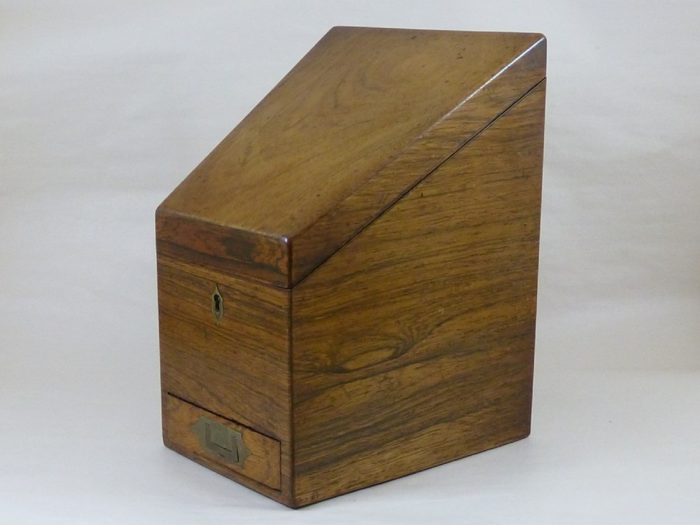 A Victorian rosewood sloping desktop stationery cabinet with open hinged lid revealing tiered light-wood compartments and a lower drawer with brass handle. View VIII