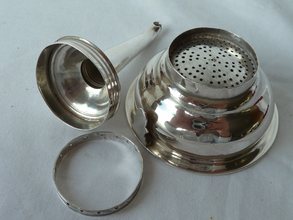 A Georgian sterling silver three-piece wine funnel shown disassembled into a pierced ring, curved spout base, and silver bowl. View III