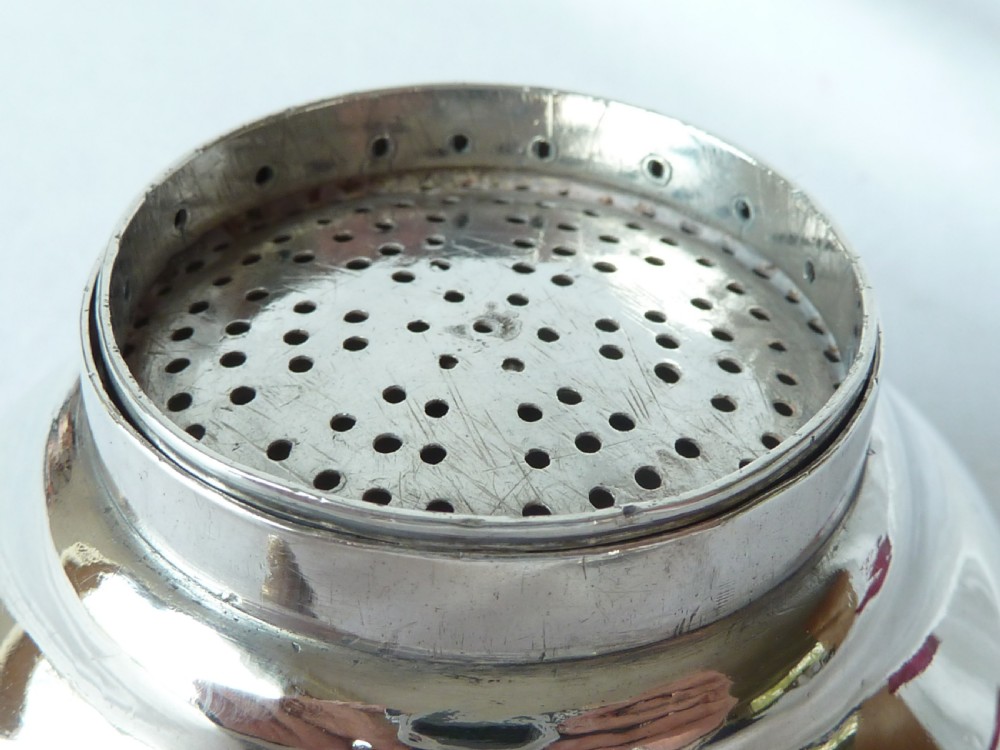 A Georgian sterling silver three-piece wine funnel shown disassembled into a pierced ring, curved spout base, and silver bowl. View IV